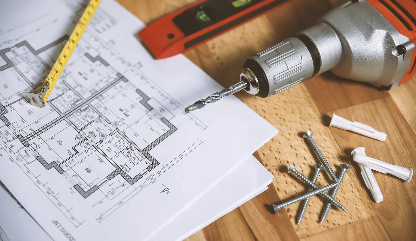 Architectural plans and construction tools on a workbench