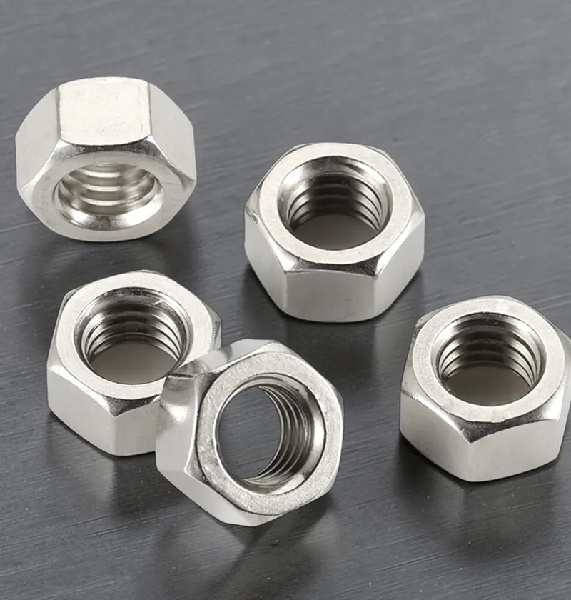 Five silver hexagonal nuts scattered on metal