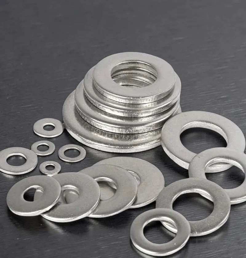 Flat silver washers of various sizes stacked and scattered