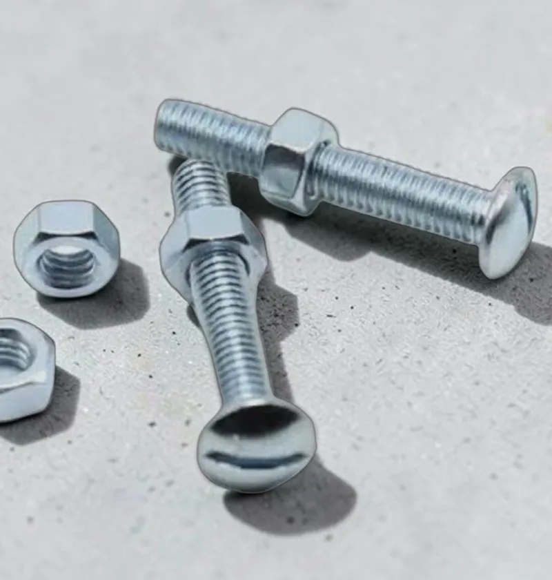 Two silver roofing bolts with nuts on a concrete surface